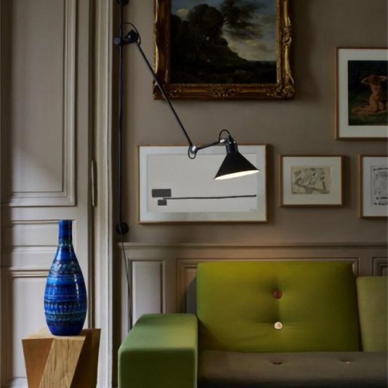 Wall light near framed art and a green chair