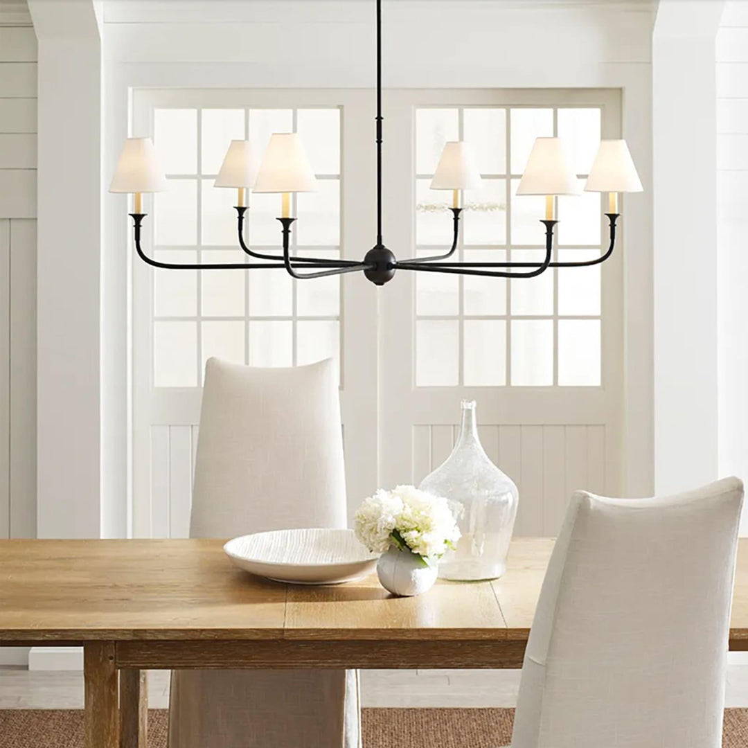 Lámpara de araña industrial moderna con pantallas de tela sobre una mesa de comedor