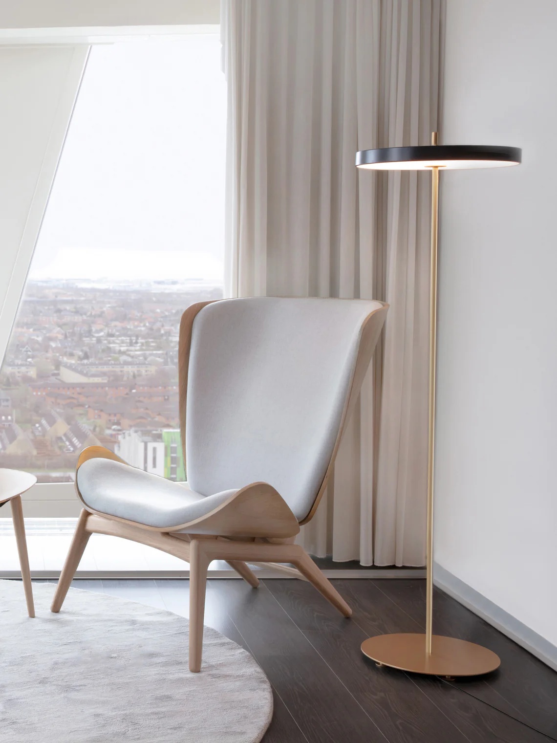 Asteria lamp beside lounge chair in bright interior