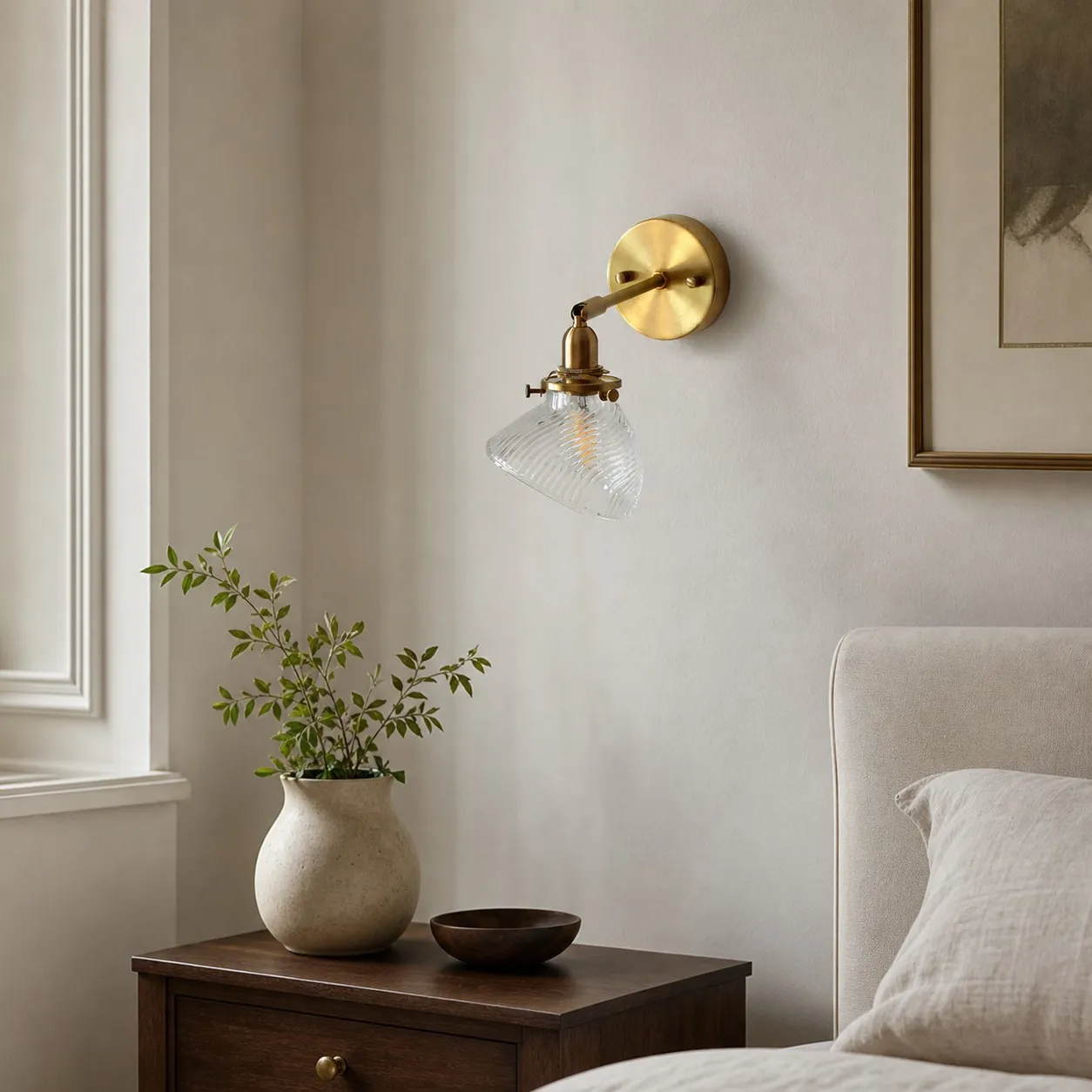 Clear glass wall lamp installed beside a bed
