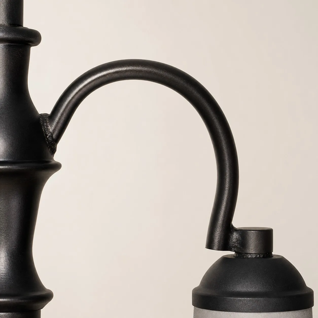 Close view of curved black iron chandelier arm